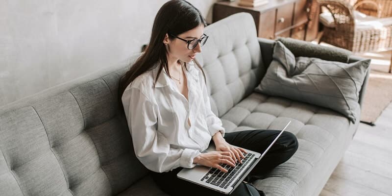 girl sitting on couch with laptop