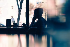 man sitting at desk in front of a laptop