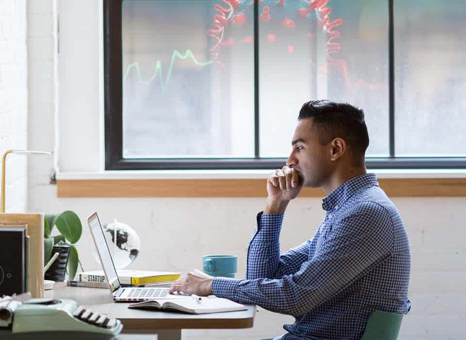 man sitting at desk looking at a computer