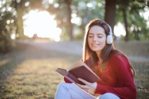 girl reading a book listening to headphones