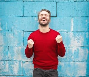 happy man in front of blue wall